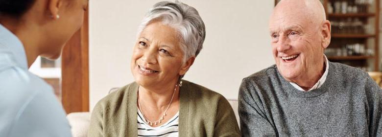 Older mixed race couple smiling at therapist